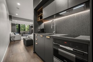 A modern kitchen with a built-in oven, a microwave, and a sink. - Spectacular Studio In Heart Of Braddon w/ Parking! (Braddon)
