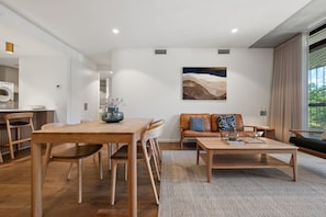Ein modernes Wohnzimmer mit einem Holzesstisch, einer Couch und einem Couchtisch.