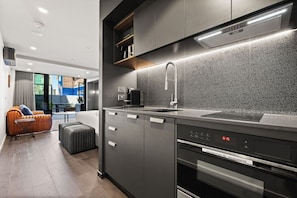 Eine moderne Küche mit integriertem Mikrowellenherd, einer Edelstahl-Spüle und einer eleganten Arbeitsplatte.