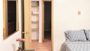 A room with a bed, a mirror, a door leading to a closet, and a vase with flowers. - 2-bedroom/2bath condo near downtown Spokane (Spokane)
