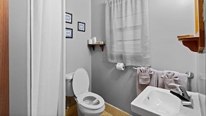 Ein Badezimmer mit Toilette, Waschbecken und Duschvorhang.