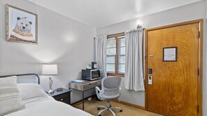 A hotel room with a bed, desk, chair, and a door. - Room 5, Kozy Rest Motel (Montello)