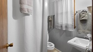 Een badkamer met toilet, wastafel en handdoekrekken.