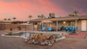 A house with a swimming pool, outdoor furniture, and a patio area.