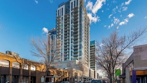 A multi-story building with a modern architectural design, located in an urban setting with a clear sky.