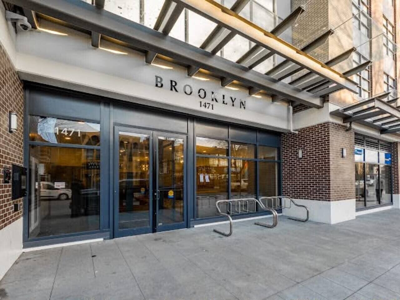 A building with a sign reading 'BROOKLYN 1471' and a glass storefront.