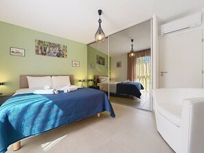 A hotel room with a bed, a chair, a mirror, and artwork on the walls. - L'Instant Azur, Beach, on foot, Clim Garage (Fréjus)