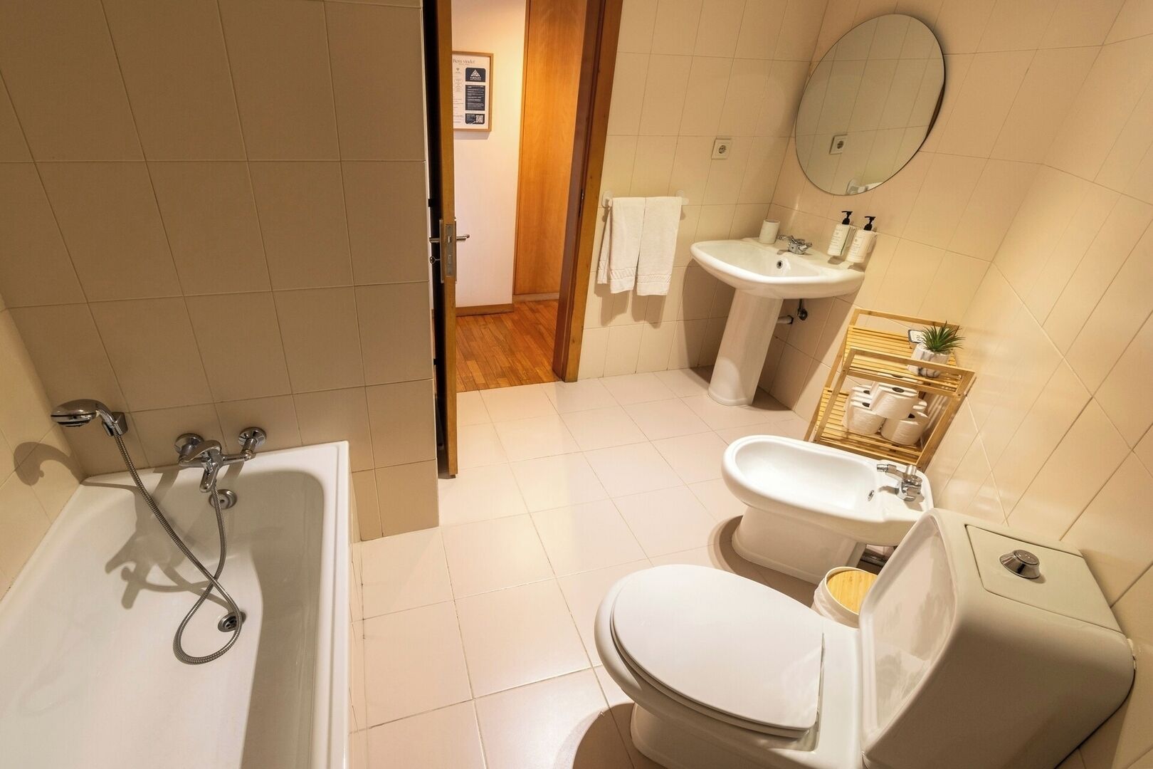 Un bagno con vasca, WC, lavandino e specchio.