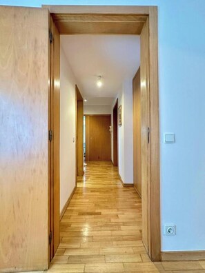 A hallway with wooden flooring and doors, leading to another room. - Douro View by Porto (Valbom)