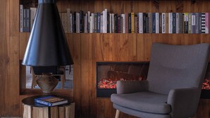 A modern interior with a bookshelf, a fireplace, and a grey armchair. - Anye Seaview Hotel Dali (Dali)