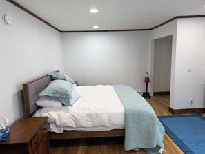 Ein Schlafzimmer mit einem Bett, einem Nachttisch aus Holz und einer Nachttischlampe.