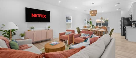 Bright open living space with comfy seating, dining area, and smart TV