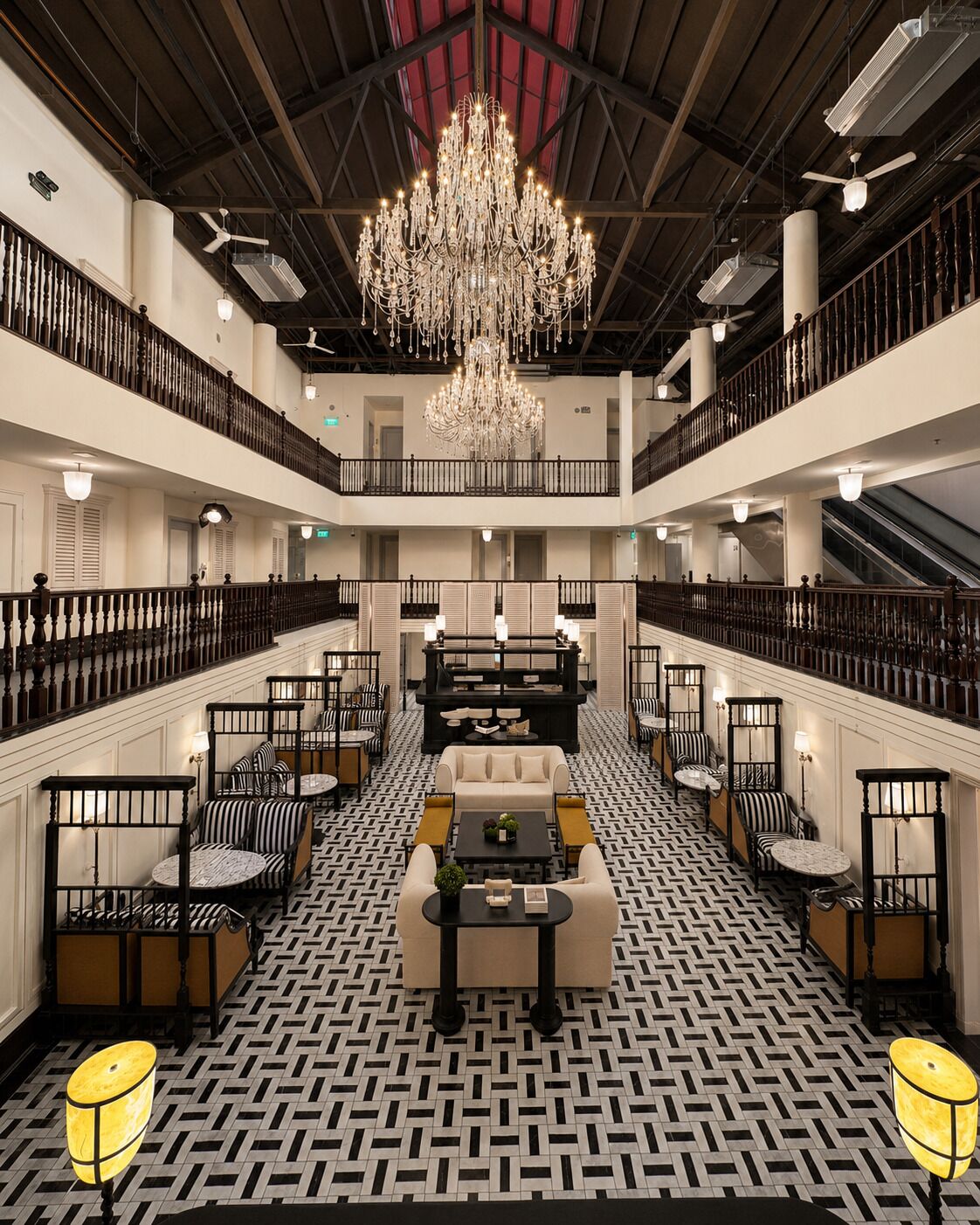 A spacious lobby with a grand chandelier, multiple seating areas, and a patterned floor.