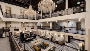 A multi-level hotel lobby with chandeliers, a staircase, and a patterned floor. - Aura Opera House Chinatown- Newly Renovated (Singapore)