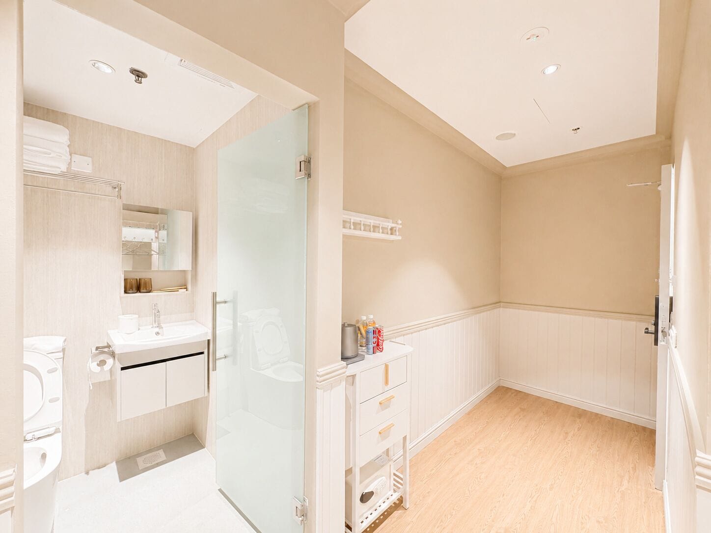 Un bagno moderno con box doccia in vetro, lavandino bianco e specchio sopra.