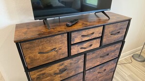 Un aparador de madera con cajones y un televisor de pantalla plana encima.