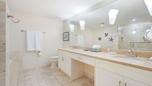 Ein modernes Badezimmer mit einem großen Spiegel, einer Badewanne, einer Toilette und einem Waschbecken.