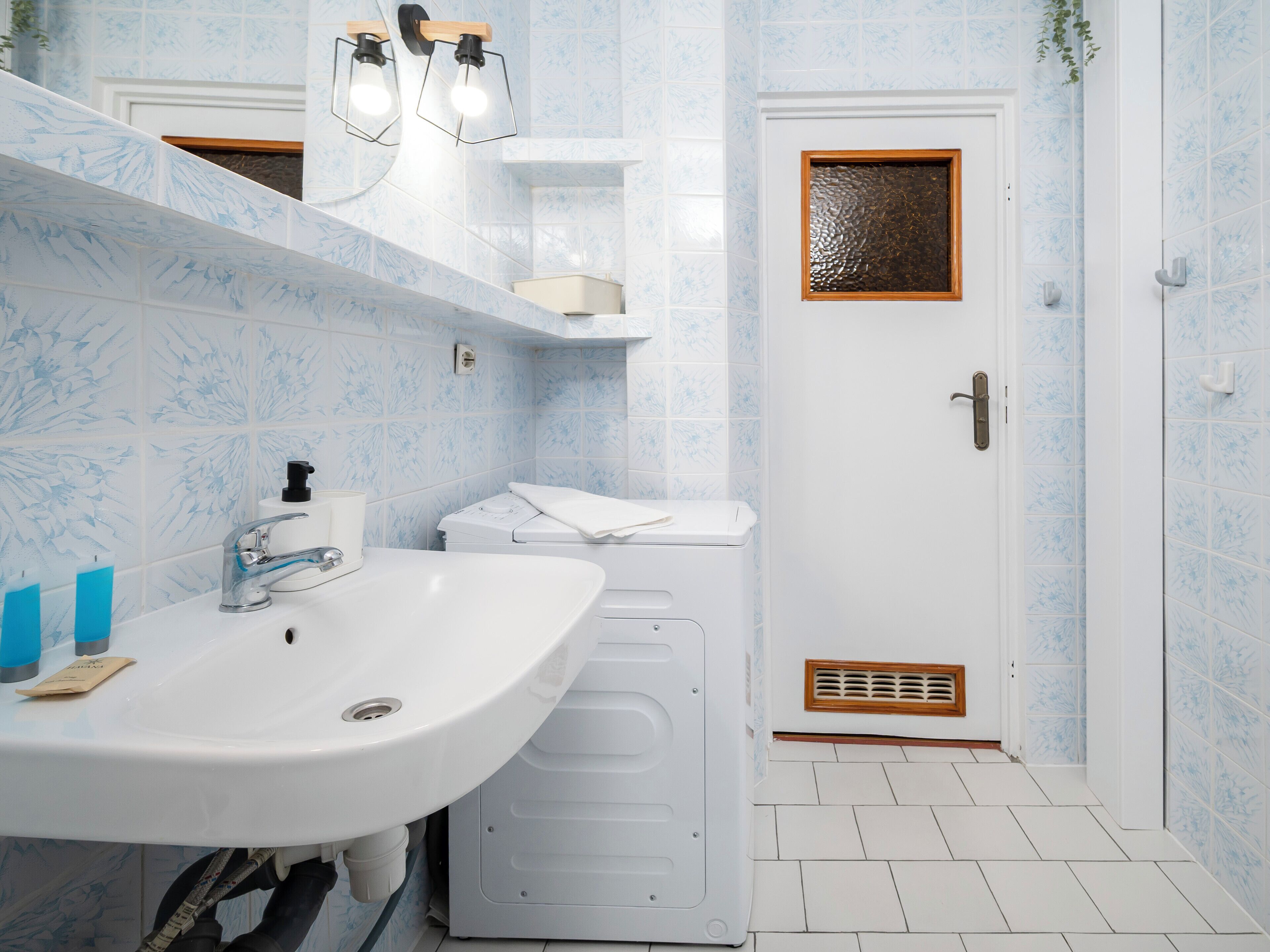 A bathroom with a sink, toilet, and washing machine.