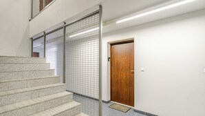 Portaat, joissa on metallikaide, puuovi ja laatoitettu seinä.