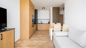 A modern apartment with a kitchen, dining area, and living room.
