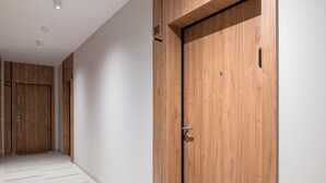 A hallway with wooden doors, numbered 88 and 90, and a tiled floor.