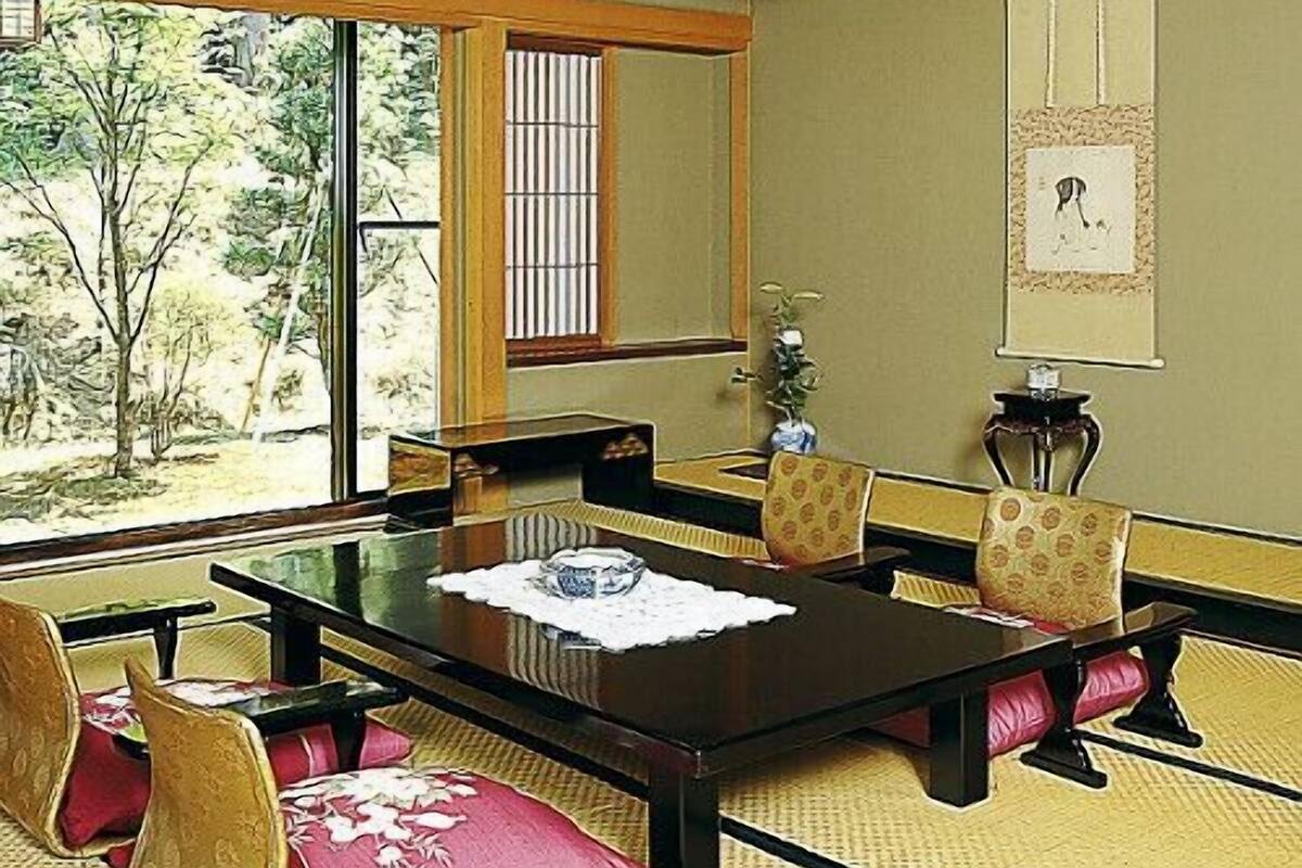 Um quarto em estilo japonês tradicional, com tatames, uma mesa baixa e painéis shoji.