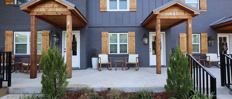 A building with a grey exterior, wooden porch columns, and a number '407' on the wall.