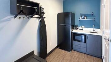 A compact kitchen with a refrigerator, a microwave, and a sink.