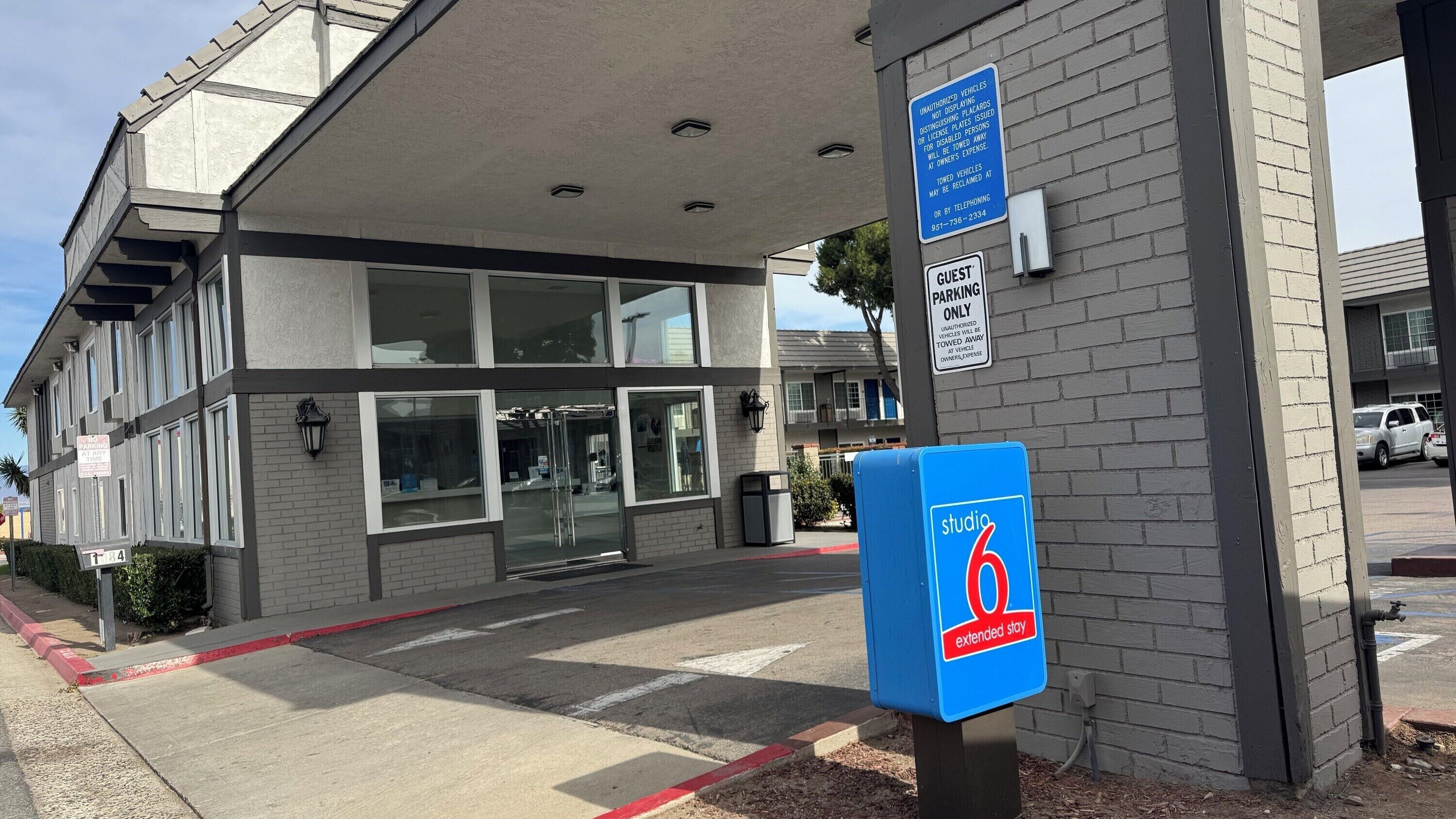 A building entrance with a blue sign indicating Studio 6 extended stay.