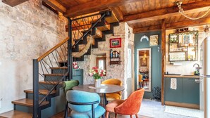 A rustic interior with a wooden staircase, a dining area with chairs, and a kitchen area. - Traditional apt in stone house in heart of Trogir (Trogir)