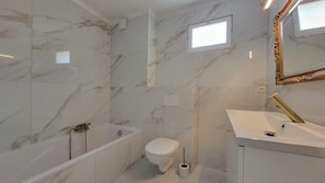 Une salle de bain avec une baignoire, des toilettes et un lavabo.