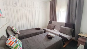 A bedroom with two beds, a sofa, a small table, and a wardrobe. - House - Sleeps 8 - Hot Tub - Beach Access (URBANIZACION BUENAS NOCHES)