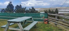 A picnic table with a view of a coastal landscape.