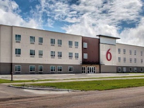 A modern building with a flat facade, multiple windows, and a prominent number '6' on the side.