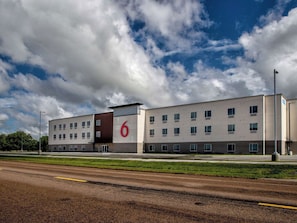 A modern building with a prominent '6' sign, multiple windows, and a flat roof.