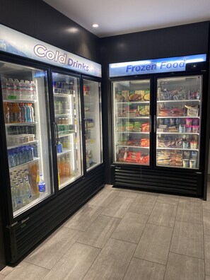 A section of a store with refrigerated freezers labeled 'Cold Drinks' and 'Frozen Food'.
