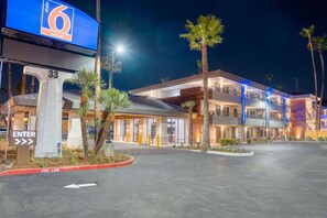 A hotel entrance with a sign for 'Studio 6 Suites' and a fire lane.
