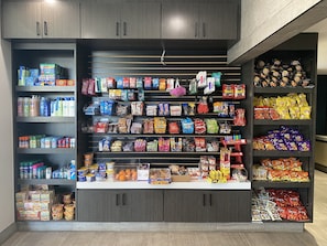 A well-organized snack and beverage display in a store with multiple shelves and a variety of products.