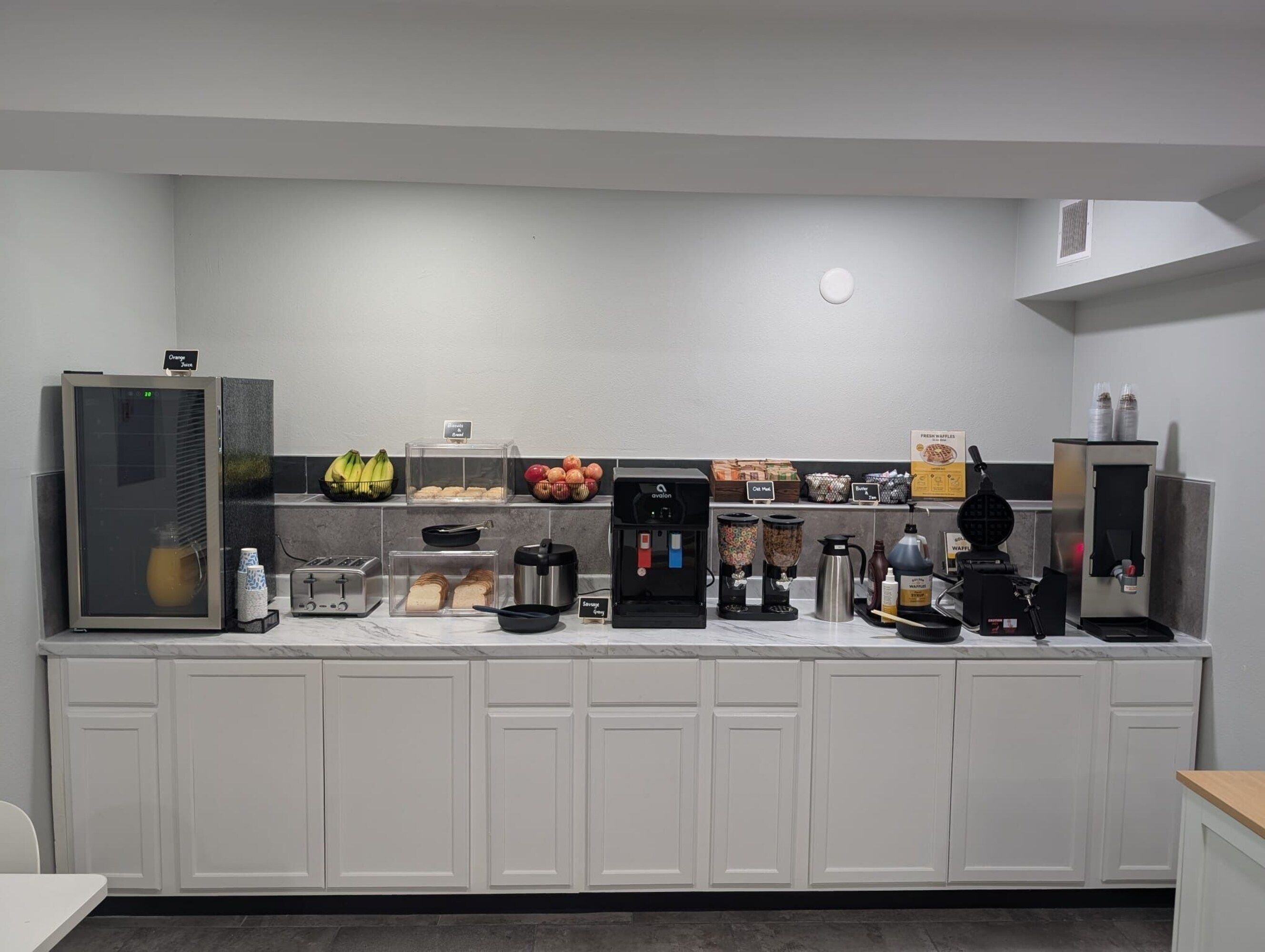 Una kitchenette equipada con cafetera, tostadora, licuadora y refrigerador.