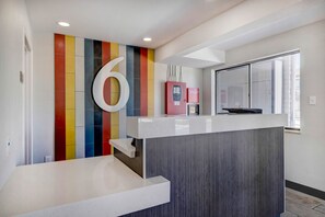 A reception desk with a large number '6' on the wall, a refrigerator, and a window with blinds. - The Perfect Balance of Adventure & Elegance w/ Free Parking | Pets Allowed (Rock Springs)