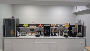 Una kitchenette equipada con cafetera, tostadora, licuadora y refrigerador.