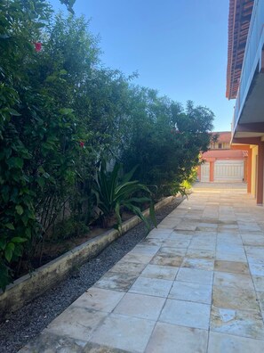 A paved pathway leading to a building with a tiled roof and a garage door. - LM Flats - Beach, Pool and Exclusivity for 20 (Aquiraz)
