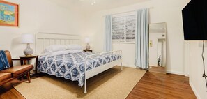 A bedroom with a bed, bedside tables, a chair, a window with curtains, and a mirror. - Unique 3-bedroom house in beautiful Chandler with cool AC comfort, huge backyard (Chandler)