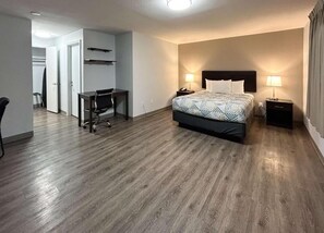Ein Hotelzimmer mit einem Bett, Nachttischen, einem Schreibtisch und einem Stuhl.