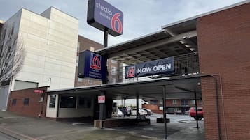 Entrada de un hotel con un cartel que indica 'Studio Suites 6' y 'ABIERTO'.