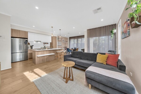A modern apartment with a kitchen, dining area, and living room.
