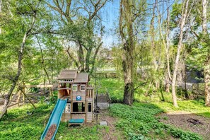 Una casita de madera con un tobogán en un área boscosa.