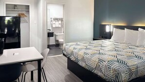 Ein modernes Hotelzimmer mit Bett, Schreibtisch, Stuhl, Kleiderschrank und Bad.