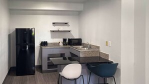 A compact kitchen with a refrigerator, microwave, coffee maker, and two chairs. - Enjoy Affordable Comfort | 2 Units in Central Irving | Pet-Friendly Stay (Irving)