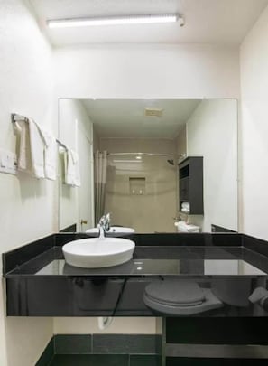 A bathroom with a large mirror, a sink, and a toilet. - Enjoy Affordable Comfort | 2 Units in Central Irving | Pet-Friendly Stay (Irving)
